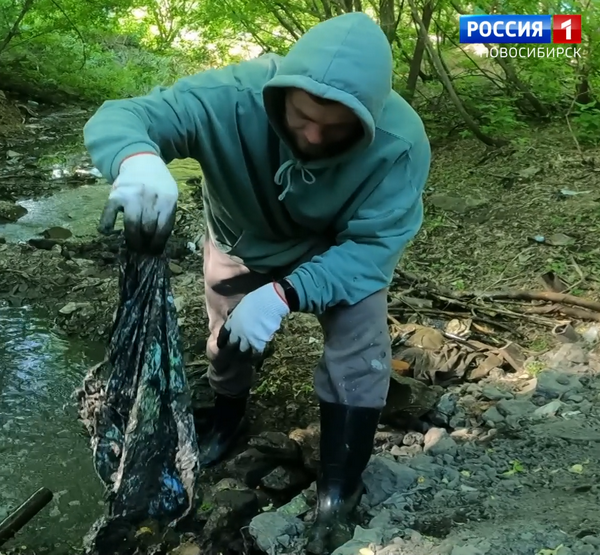 Рабочий очищает реку от мусора Рабочий очищает реку от мусора