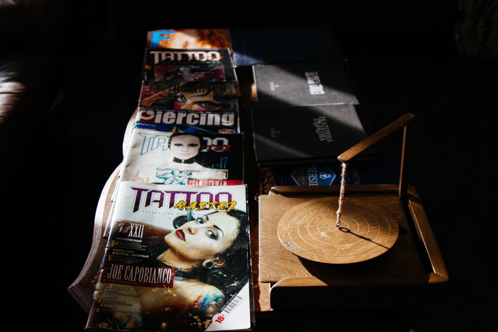 Стол ресепшн усеян журналами о татуировках и пирсинге, можно найти эскизы и работы тату-мастеров салона.