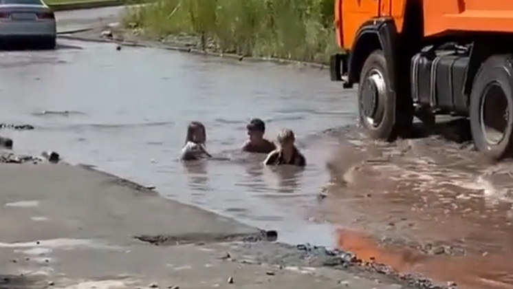Дети купались в огромной луже посреди дороги в Новосибирске