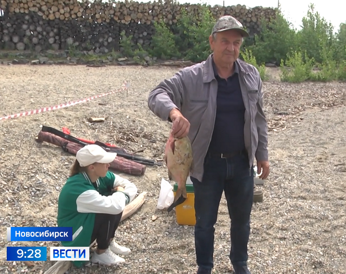 Рыбак показывает пойманного леща