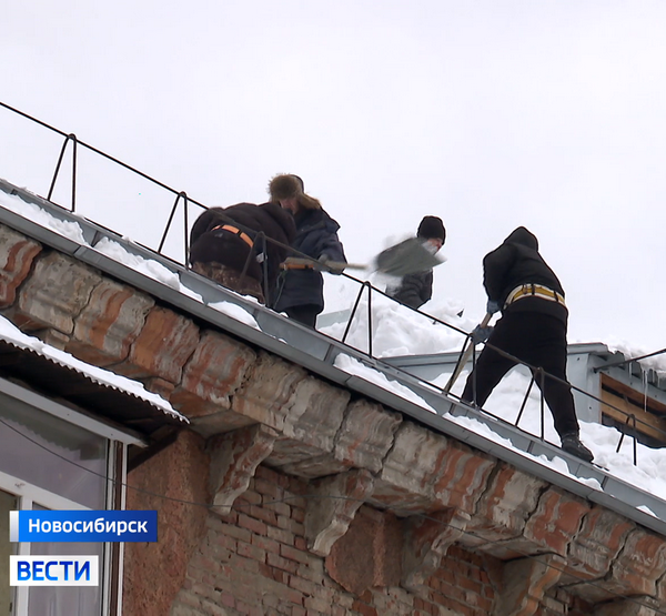 убирают снег с крыши