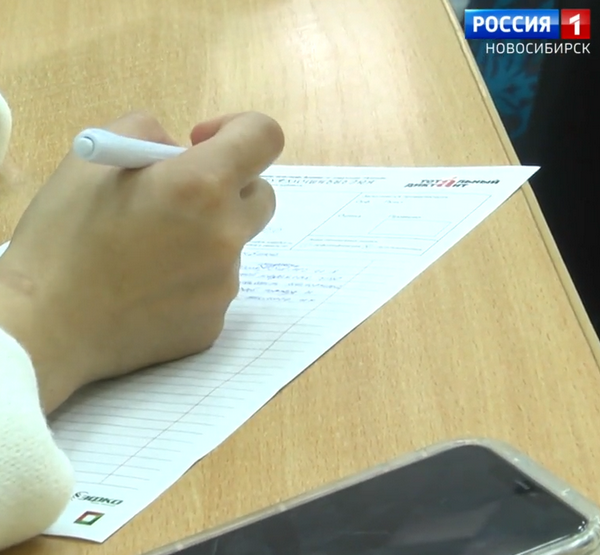 Девушка пишет текст диктанта