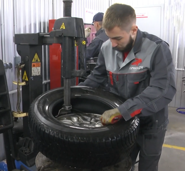 Шиномонтажник меняет шину
