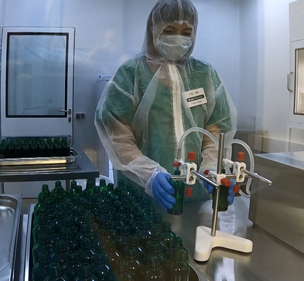 Сотрудница компании набирает хлореллу в бутылки