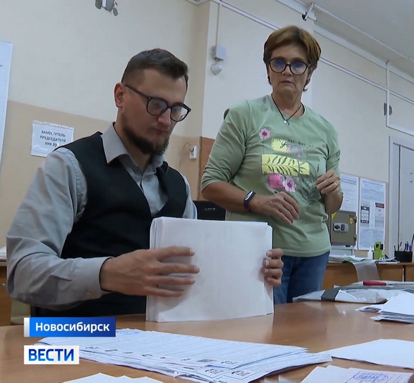 Стопки бюллетеней в руках члена УИК