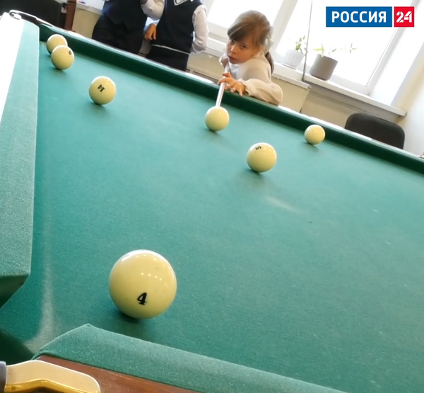 Девочка играет на бильярде