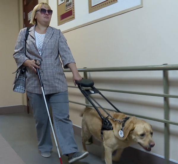 Слабовидящая избирательница с собакой-поводырём идет голосовать