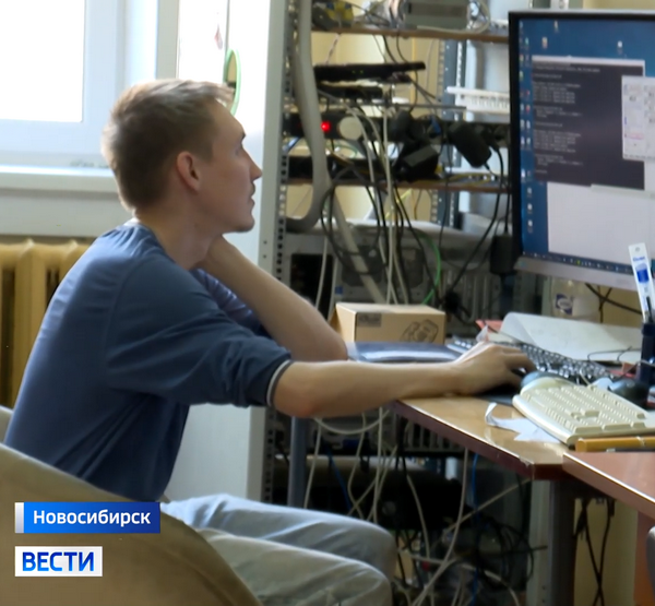 Молодой учёный сидит за монитором