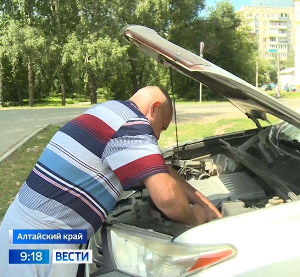 Водитель осматривает двигатель машины