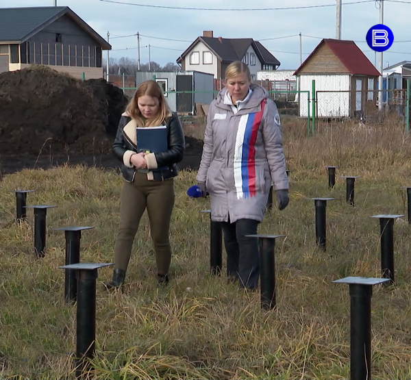 Корреспондент «Вести Новосибирск» и клиентка фирмы «Мегадом» идут по участку со сваями