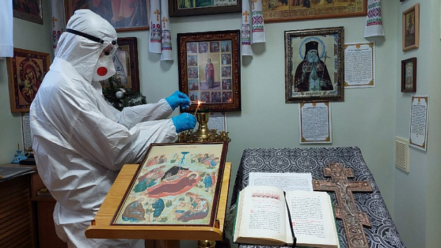 В Новосибирске священнослужитель в защитном костюме посетил ковидный госпиталь в Рождество